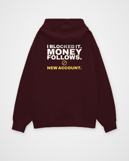 Maroon oversized hoodie, back view, print reading I blocked it. Money follows. New account – digital mockup