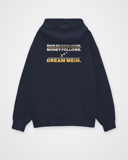Navy Blue oversized hoodie, back view, print reading Main so raha hoon. Money follows. Dream mein – digital mockup