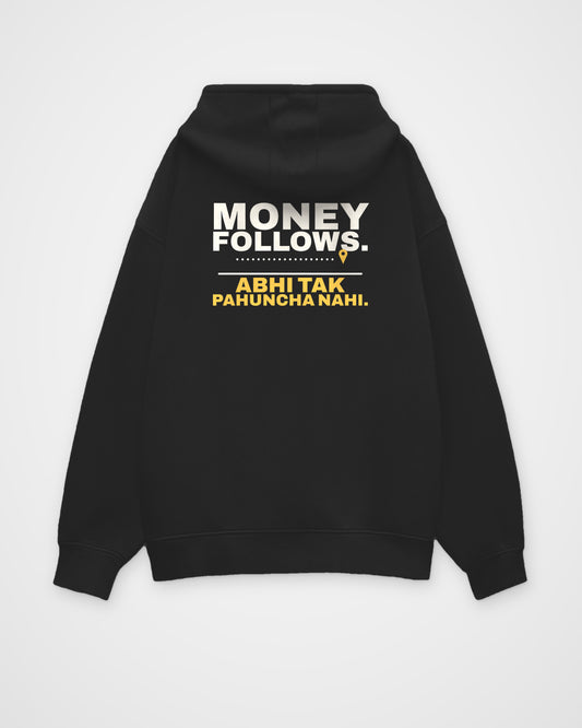 Black oversized hoodie, back view, print reading Money follows. Abhi tak pahuncha nahi – digital mockup
