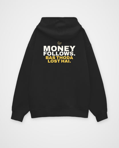 Black oversized hoodie, back view, print reading Money follows. Bas thoda lost hai – digital mockup