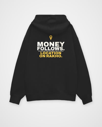 Black oversized hoodie, back view, print reading Money follows. Location on rakho – digital mockup