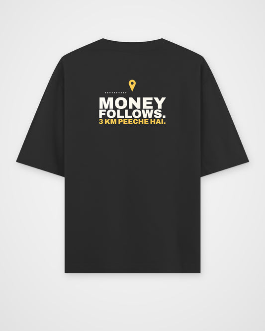 Black oversized tee, back view, print reading Money follows. 3 km peeche hai – digital mockup