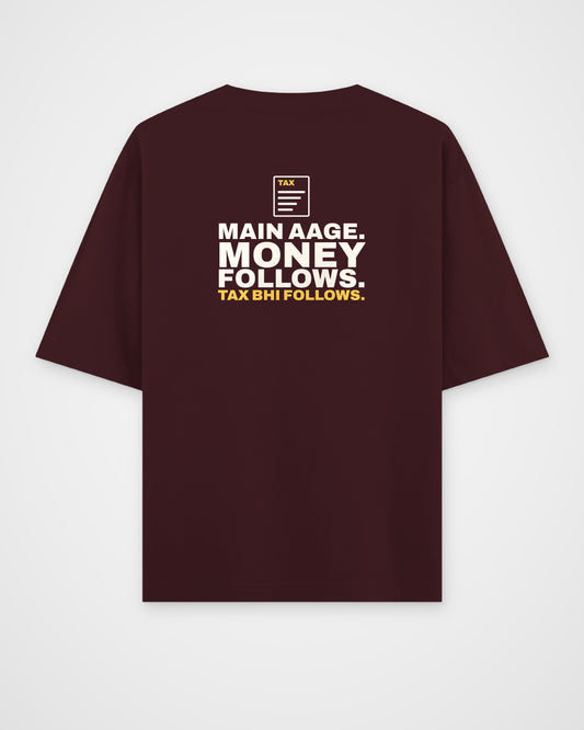 Maroon oversized tee, back view, print reading Main aage. Money follows. Tax bhi follows – digital mockup