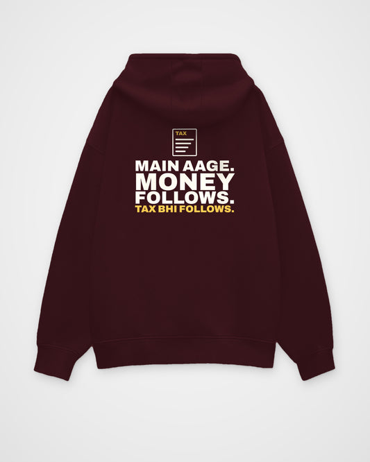 Maroon oversized hoodie, back view, print reading Main aage. Money follows. Tax bhi follows – digital mockup