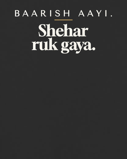 Black oversized t-shirt, close-up of the back print reading Baarish aayi. Shehar ruk gaya – digital mockup