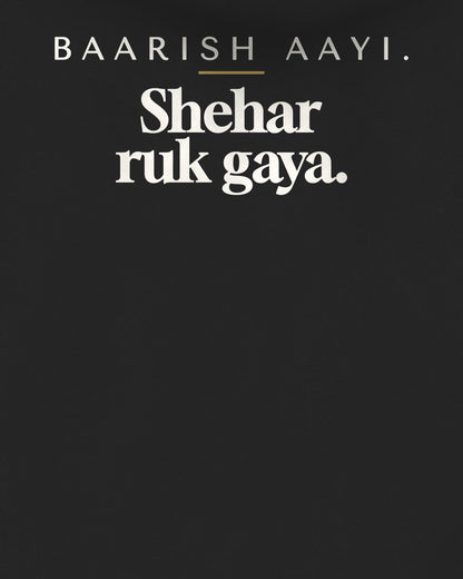 Black oversized hoodie, close-up of the back print reading Baarish aayi. Shehar ruk gaya – digital mockup