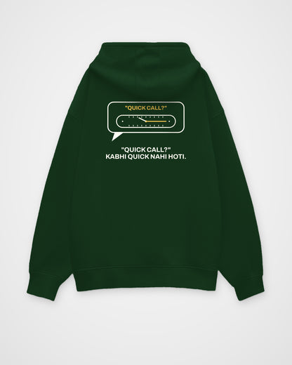 Bottle green oversized hoodie, back view, with a QUICK CALL? speech bubble with a stretching clock and – digital mockup