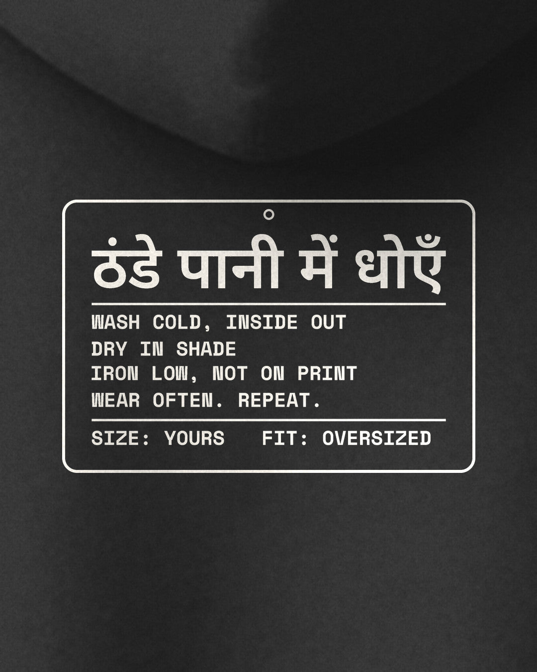 Black oversized hoodie, close-up of the Care Label print