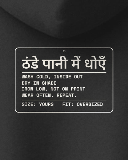 Black oversized hoodie, close-up of the Care Label print