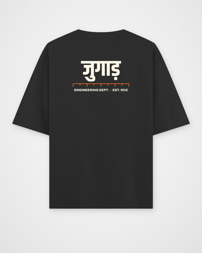 Black oversized t-shirt, back view, a big Hindi wordmark reading jugaad, a ruler and ENGINEERING DEPT. EST – digital mockup
