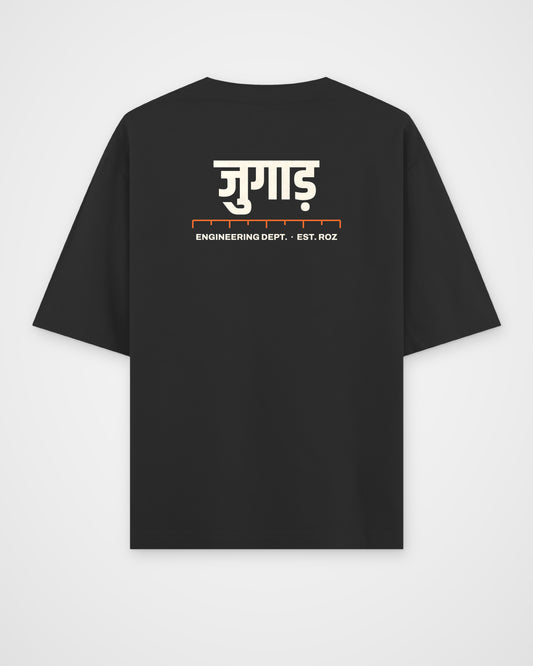 Black oversized t-shirt, back view, a big Hindi wordmark reading jugaad, a ruler and ENGINEERING DEPT. EST – digital mockup