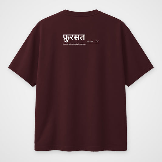 Maroon oversized t-shirt, back view, with a small Hindi dictionary entry for फ़ुरसत across the upper back