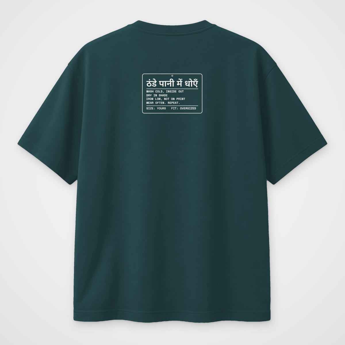 Petrol blue oversized t-shirt, back view, with a care-label style print in Hindi and English