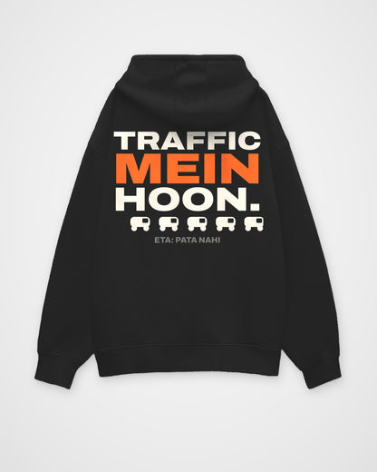 Black oversized hoodie, back view, full-width stacked TRAFFIC MEIN HOON. type, a rickshaw icon row and ETA: – digital mockup